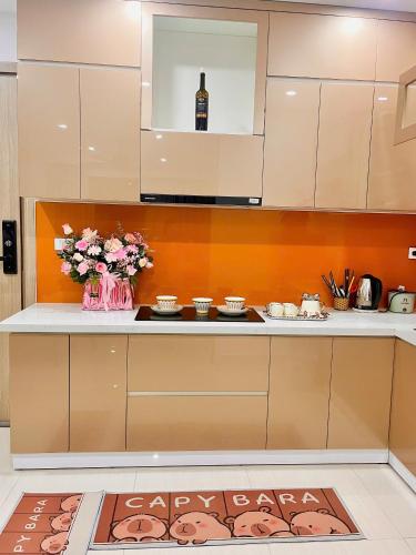 a kitchen with a counter with flowers and a bottle of wine at Châu Giang Homestay, Nera Garden Huế in Thôn Văn Dương