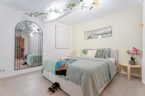 ein weißes Schlafzimmer mit einem Bett und einem Spiegel in der Unterkunft Escale Zen - Sauna Exclusif & Terrasse Privée - Idéal Pro & Couple - Piscine - 5min Port Toulon & Plage - WIFI HD - Expérience premium "Dans une bulle" in Toulon
