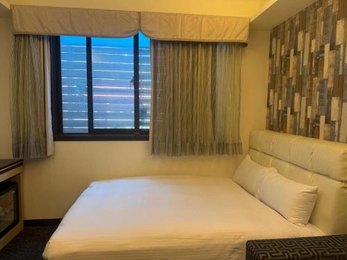 a bed in a room with a large window at Fairy Tale City Motel in Hualien City