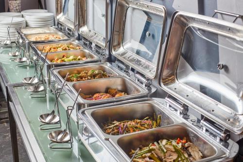 a buffet line with trays of food on a table at Summit Hotel Tacloban in Tacloban