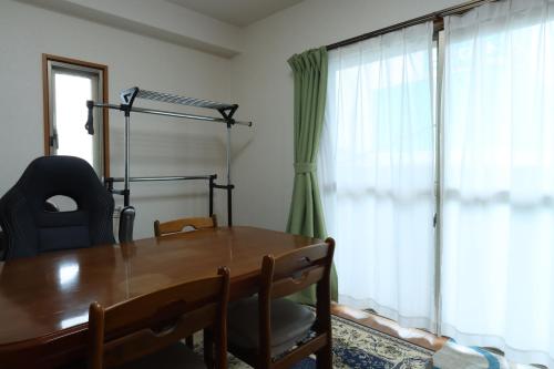 a dining room with a wooden table and a window at Ikkyu For Backpackers 19 in Hitoyoshi