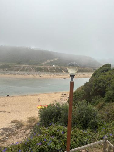 a street light sitting next to a beach at Mira-mar in Odeceixe