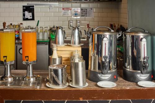 a kitchen counter with two kettles and two orange juice at Summit Hotel Tacloban in Tacloban