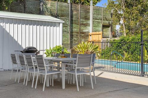 a table and chairs sitting next to a fence at The Palms in Coolum Beach - Unit B in Coolum Beach