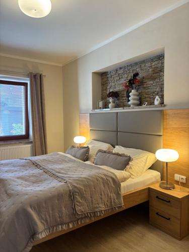a bedroom with a large bed with two lamps at Penzion Apartmány Resident in Poděbrady