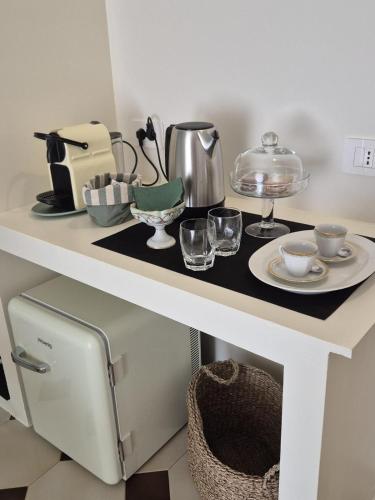 a white table with a plate and glasses on it at Casa Graziella in Capo dʼOrlando