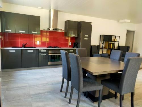 a kitchen with a wooden table and chairs at Le Plain-pied du Pêcheur - Maison avec terrasse entre Loire, Via Velay et Le Puy in Brives-Charensac