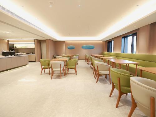 a restaurant with tables and chairs and a kitchen at JI Hotel Beijing Yanqing Tower Wanda Plaza in Yanqing