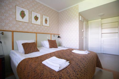 a hotel room with two beds with towels on them at Hotelli Verstas in Nakkila