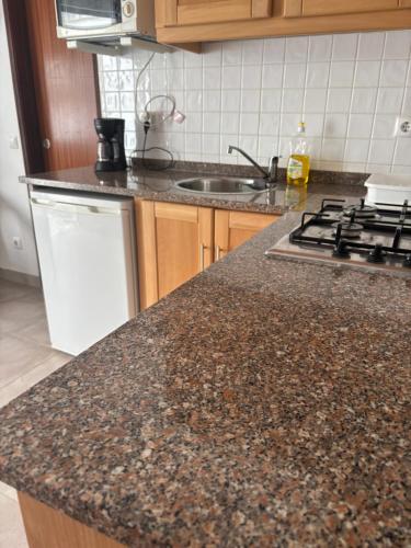 a kitchen with a granite counter top and a sink at Mira-mar in Odeceixe