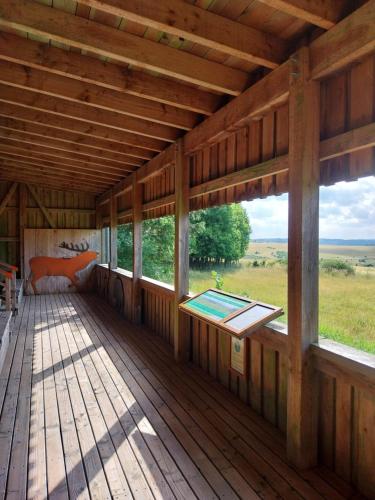 a large wooden porch with a bed and windows at Ferienwohnung EifelReich in Dreiborn