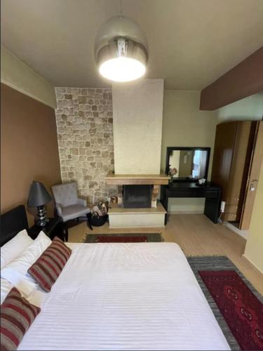 a bedroom with a large bed and a fireplace at Mountain View in Synikia Mesi Trikalon
