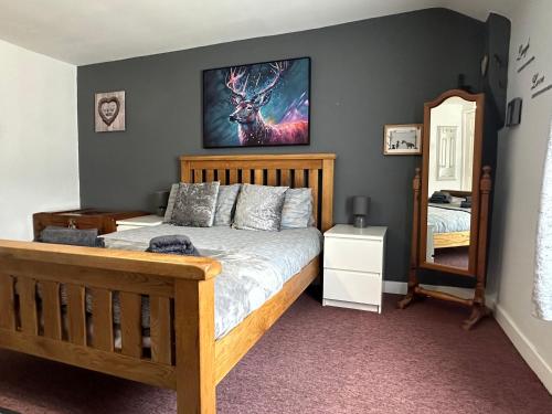 a bedroom with a bed with a deer on the wall at Llanidloes Townhouse-pet-friendly-sleeps 7-Mid Wales in Llanidloes