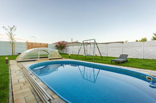 a swimming pool with a slide and a playground at Pet-house in Trstice