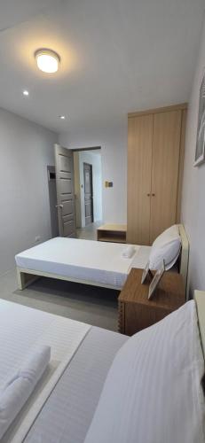 a large room with two beds and a desk at Cozypod Rentals in Sagcahan