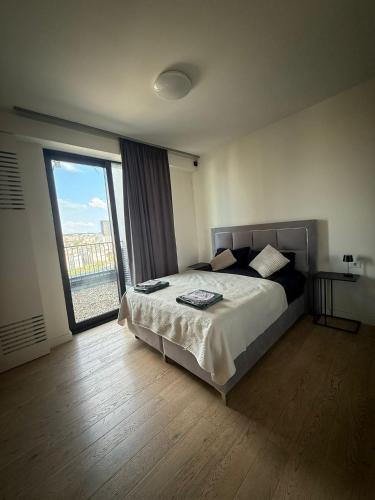ein Schlafzimmer mit einem Bett und einem großen Fenster in der Unterkunft Belgrade Waterfront apartments in Belgrad