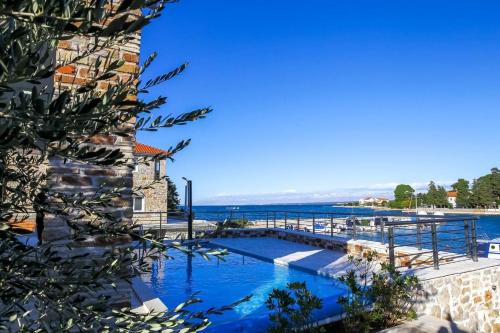 a swimming pool with a view of the ocean at Steinhaus Mediterra mit Pool & Meerblick - Lukoran, Insel Ugljan bei Zadar in Lukoran