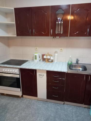 a kitchen with brown cabinets and a sink at MaryAnne in Ledine