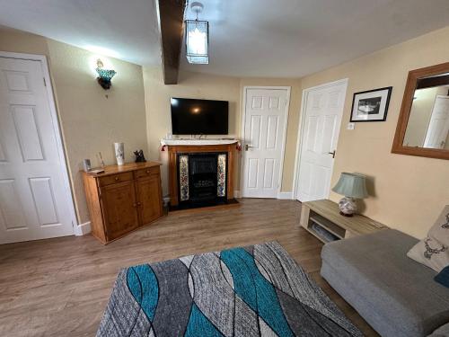 a living room with a fireplace and a tv at Llanidloes Townhouse-pet-friendly-sleeps 7-Mid Wales in Llanidloes