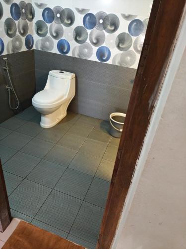 a bathroom with a toilet and plates on the wall at Sunshine beach resort in Varkala