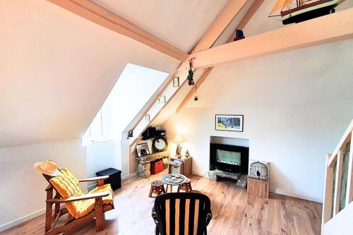 a living room with a vaulted ceiling and a tv at Spacious cocoon near the sea in Saint Malo