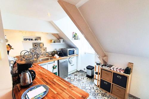 a kitchen with a wooden table in a room at Spacious cocoon near the sea in Saint Malo