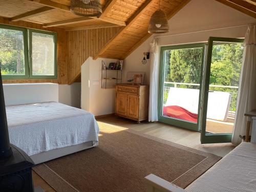 Un dormitorio con una cama y una puerta corrediza de vidrio. en Two Pines Summer House in Tihany, Sajkod, en Tihany