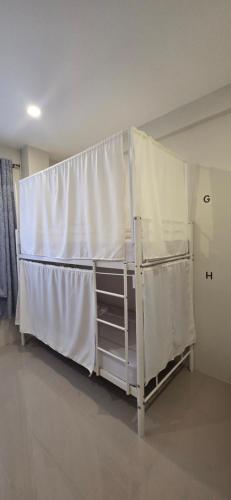 a bunk bed in a room with white curtains at Cozypod Rentals in Sagcahan