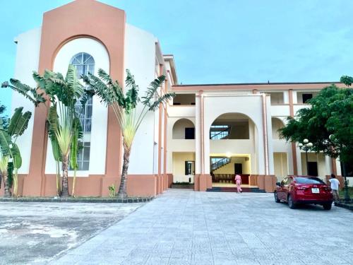 a red car parked in front of a building at Hồng Ân Motel Quảng Trị in Quảng Trị