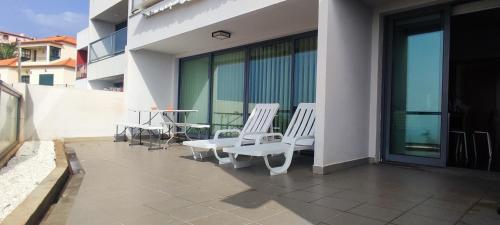 a balcony with chairs and a table on a building at Moradia Garcês in Santa Cruz