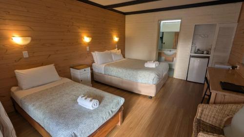 ein kleines Zimmer mit 2 Betten und einer Küche in der Unterkunft Gloucester Motel Pemberton Manjimup in Pemberton