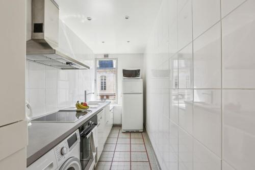a kitchen with white appliances and a white refrigerator at BnBNova - 1BR with Balcony - Trocadero & Arc de Triomphe in Paris