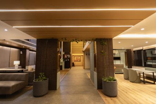 a lobby with a couch and a table and chairs at Pride Biznotel Alkapuri Near Vadodara Airport in Vadodara