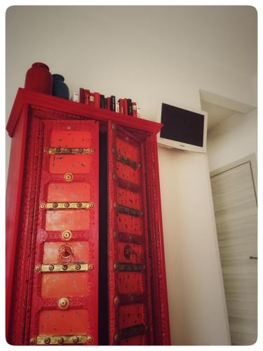 a red cabinet in a room next to a wall at Festina Lente B&B in Porto Recanati