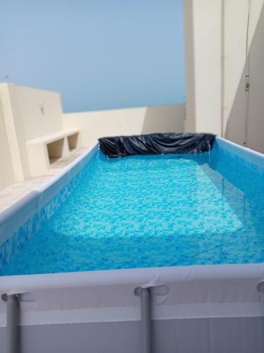 Una piscina con agua azul en una habitación. en Al Jiwirah Night Chalate, en Camp
