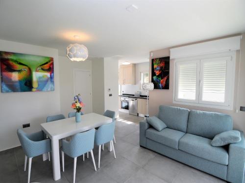 ein Wohnzimmer mit einer Couch und einem Tisch und Stühlen in der Unterkunft Estancia Rojales con Jardín in Rojales