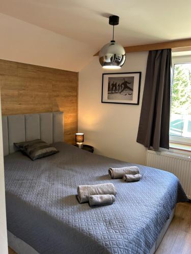a bedroom with a bed with two towels on it at Apartmány Gryf Harrachov in Harrachov