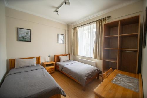 a bedroom with two beds and a window at Zaya Stays, Cozy Private Family Apartment in the city center in Ulaanbaatar