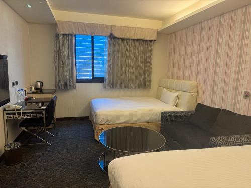 a hotel room with two beds and a couch at Fairy Tale City Motel in Hualien City