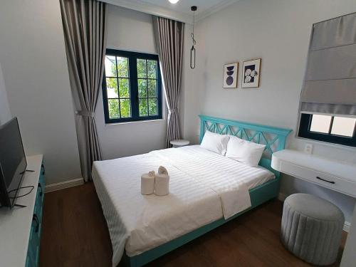 a bedroom with a blue and white bed and a sink at Villa Nova Quân Nhân 4 in Bình Tú