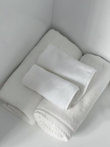 four white towels sitting on top of a shelf at Villa Nova Quân Nhân 4 in Bình Tú