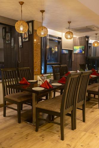 a dining room with a table and chairs and lights at Pride Biznotel Alkapuri Near Vadodara Airport in Vadodara