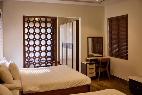 a bedroom with a bed and a mirror and a desk at Yên Riverside Villa - Homestay Huế in Hue