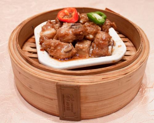 a wooden plate of food with meat and vegetables at Hotel Silverland in Dongguan