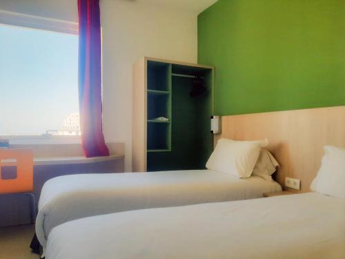 a bedroom with two beds and a green wall at Premiere Classe Casablanca Centre Ville in Casablanca
