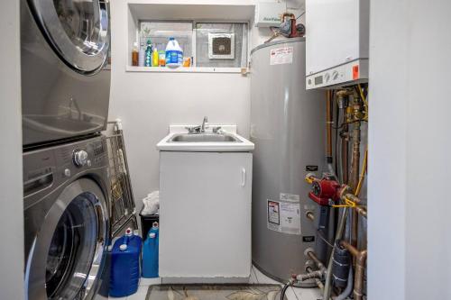a kitchen with a washing machine and a sink at Garden Suite near Jericho Beach in Vancouver