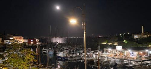 a marina at night with a street light and boats at casetta sul porticciolo in Stintino