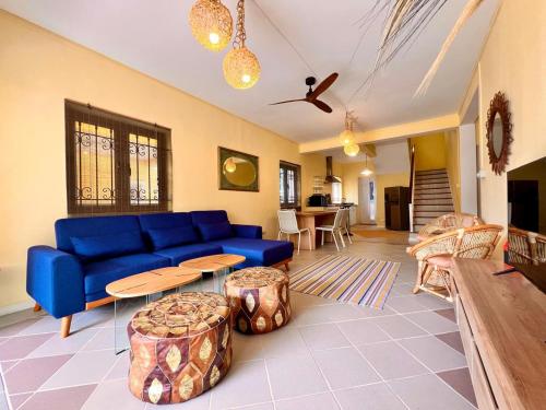 a living room with a blue couch and tables at Beach Villa Coco in Palmar