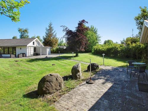 a patio with rocks and a table in a yard at 6 person holiday home in Gedser-By Traum in Gedser