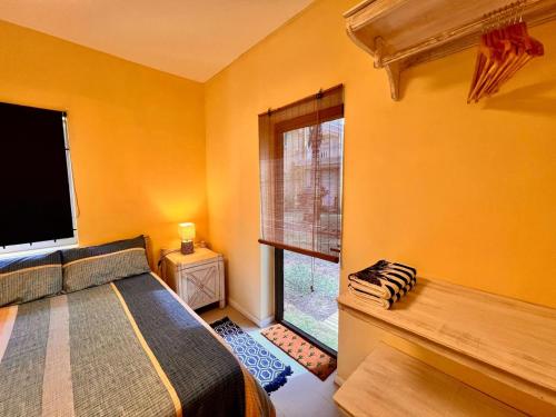 a bedroom with a bed and a large window at Beach Villa Coco in Palmar